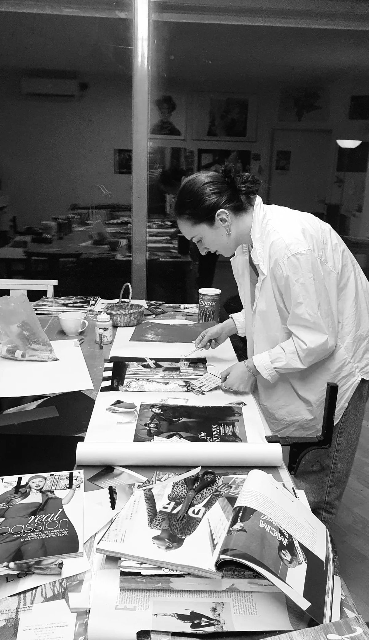 Hannah Staib at her studio table surrounded by paintings and clippings